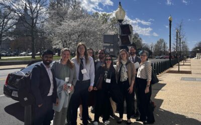 A group of people in a portrait photo standing outside Capitol Hill in Washington DC.