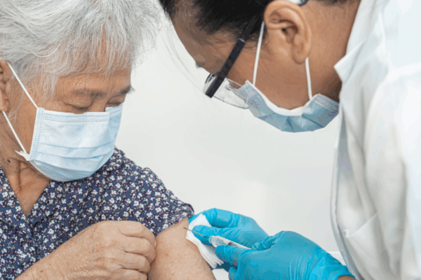 Elderly woman receiving a vaccine