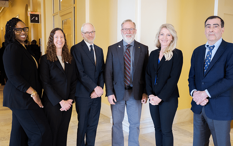 Speakers for the AAI Congressional Briefing stand in the halls of the House Office Building.