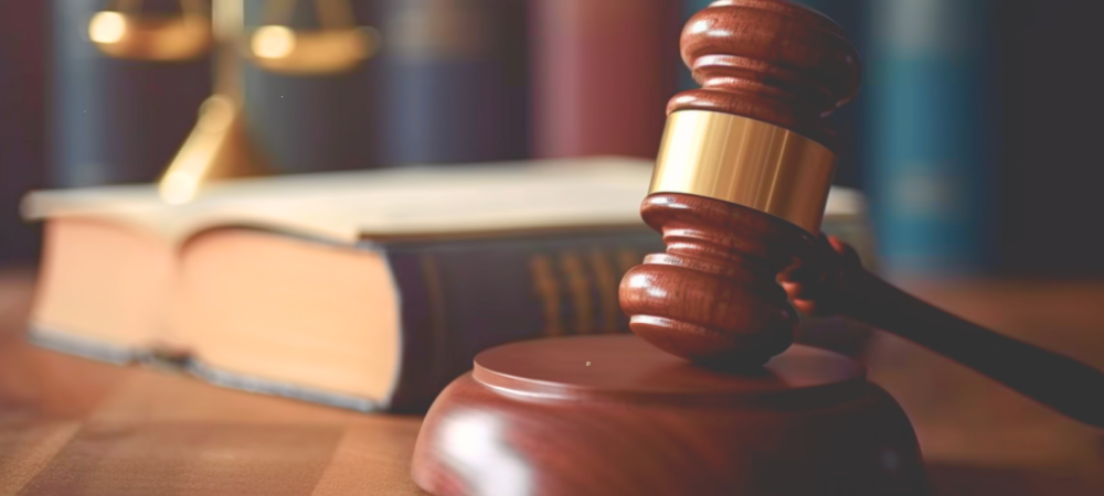 close up of a gavel with a book and scales in the background