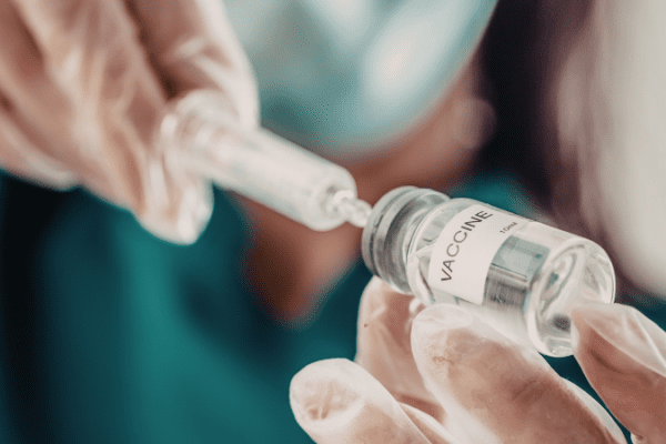 doctor drawing up a dose from a vaccine vial