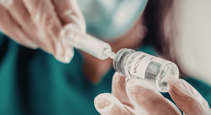 doctor drawing up a dose from a vaccine vial