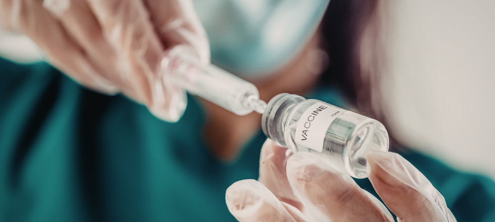 doctor drawing up a dose from a vaccine vial