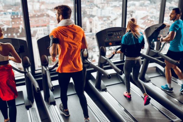 Four people running HIIT workouts beside each other on treadmills