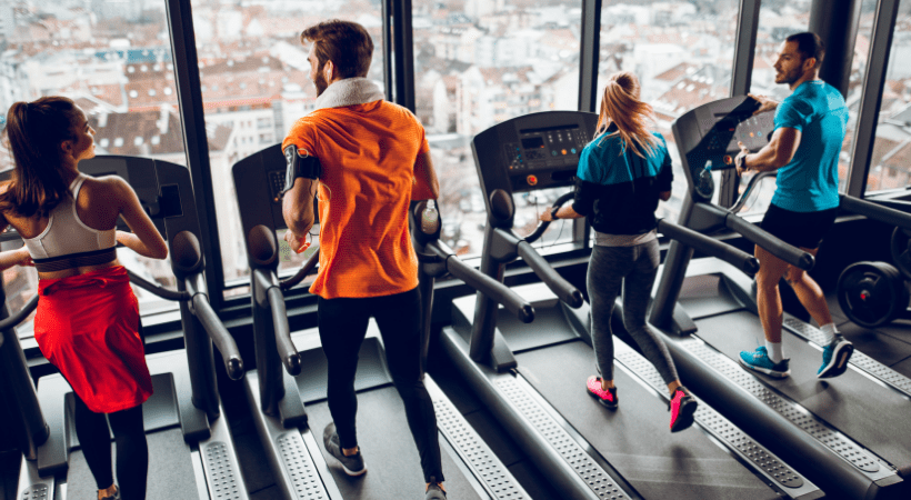 Four people running HIIT workouts beside each other on treadmills