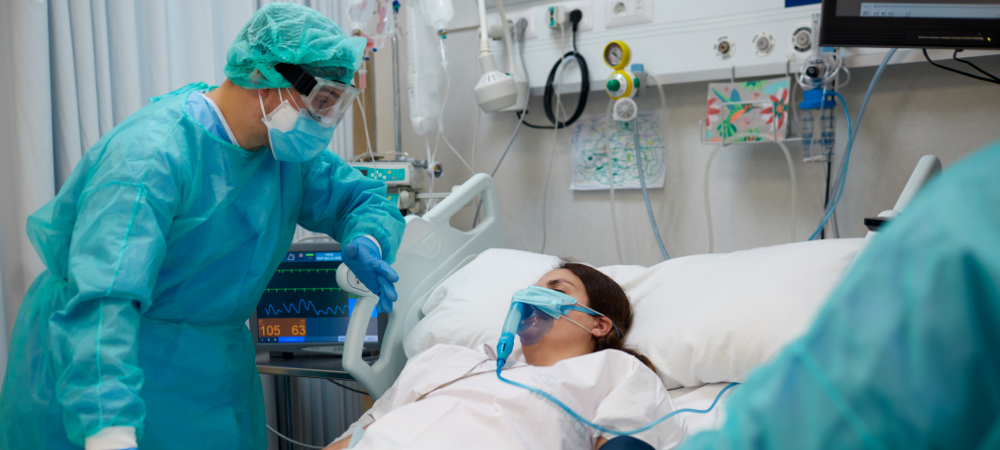 Woman in ICU after traumatic injury with nurse attending to her