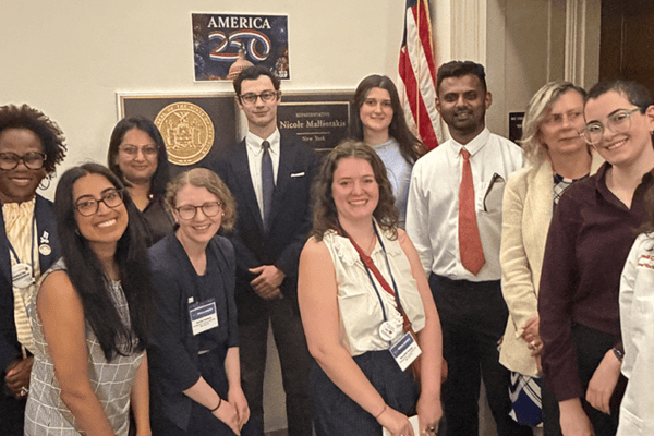 A group of immunologists pose with members of a congressional office
